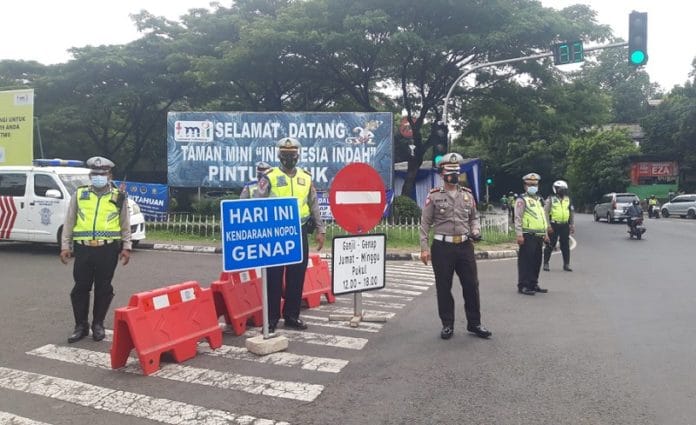 ganjil genap polisi menjaga kawasan pemberlakuan sistem lalu lintas Ganjil genap
