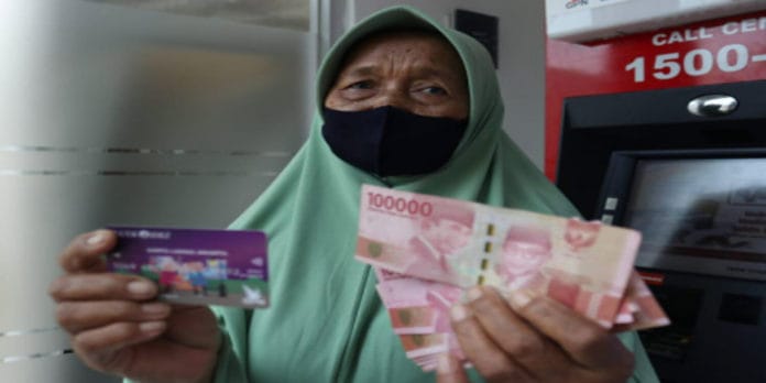 lansia-terima-bantuan-klj (1) Seorang lansia menunjukan bukti penerimaan uang dari KLJ. (Sumber: beritajakarta.id)